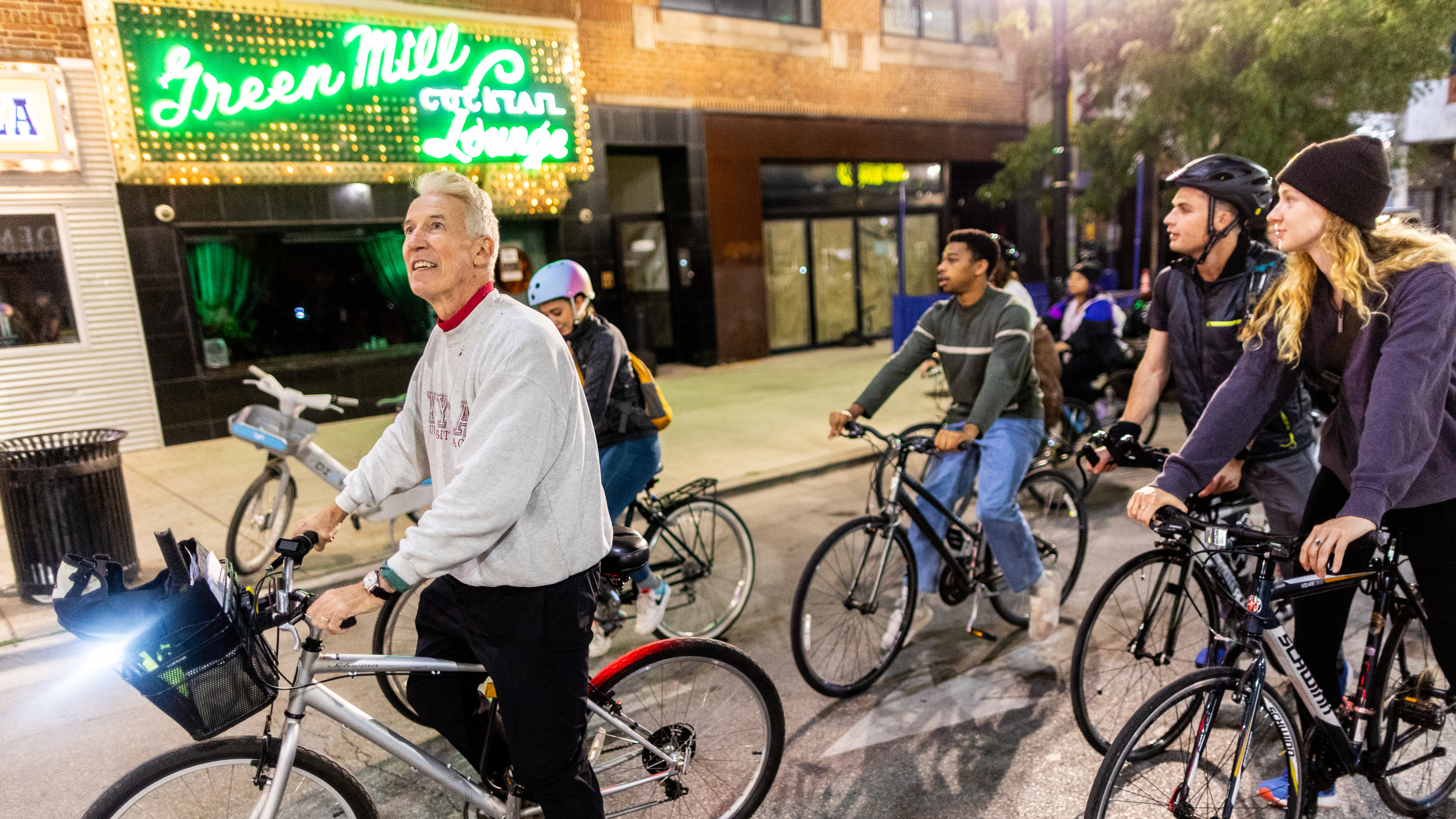 Loyola Professor Timothy Gilfoyle leading students on a bike through historic Chicago neighborhood U